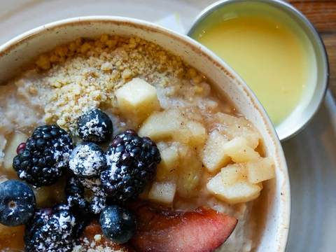 A bowl of porridge with berries and crumble